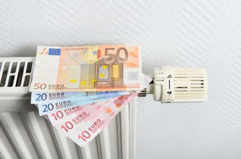 Heizkörper mit Euro-Geldscheinen als Sinnbild für steigende Heizkosten